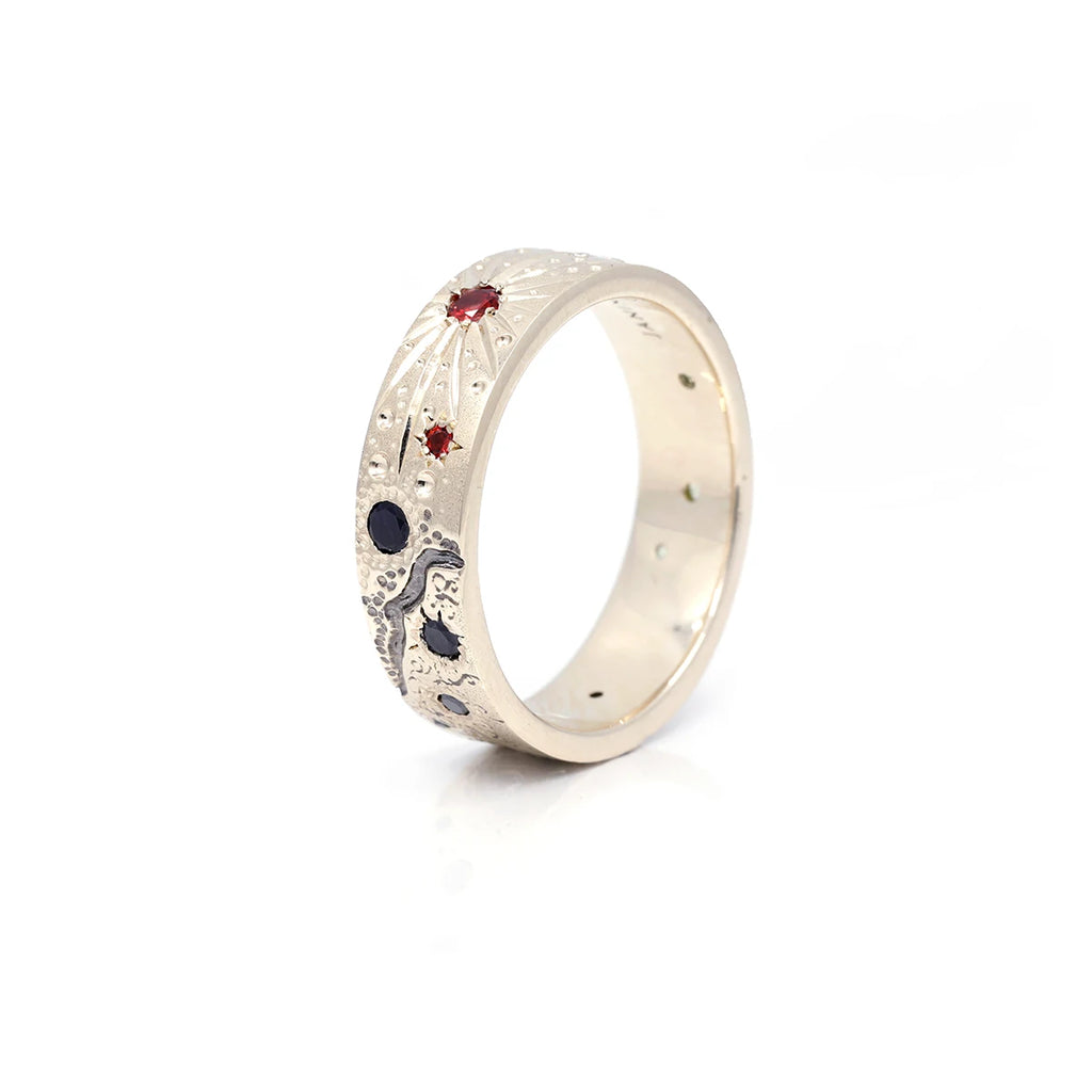Recycled white gold wedding band showing a galaxy made of gemstones: black diamonds, rubies, sapphires and lab grown diamonds.