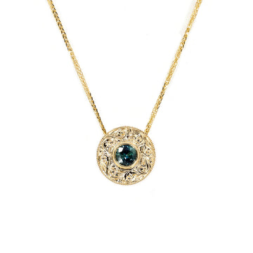 The Montreal jewelry store Ruby Mardi presents the fine jewelry of Deborah Lavery, Canadian jewelry designer, splendid pendant in yellow gold with a magnificent teal sapphire in a round shape with a handmade partern. This fine piece of jewelry is available for sale at our jewelry gallery and biouterie located in the Rosemont and Villeray district.