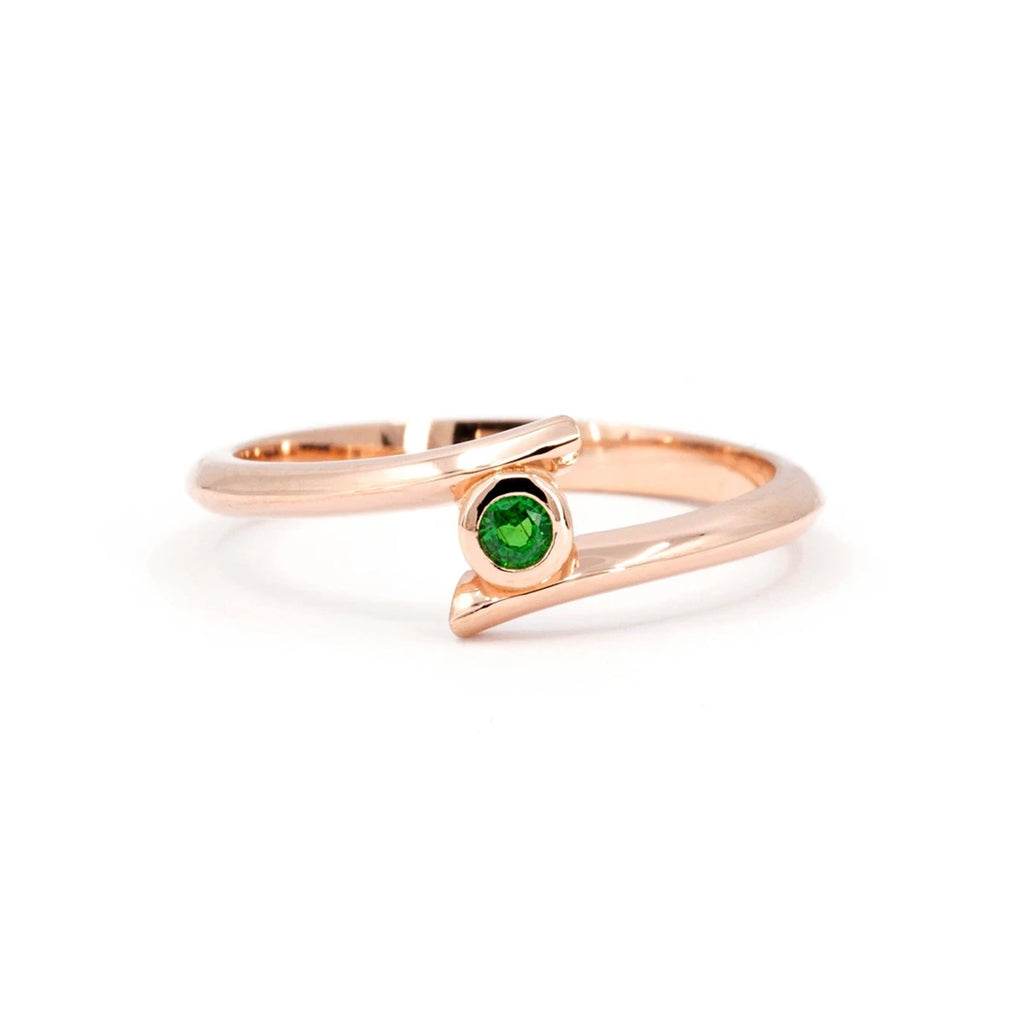 The Ruby Mardi jewelry store presents the Kink ring with a green garnet from the demantoid family. Mounted on pink gold with a bezel setting, this alternative engagement ring is a custom creation available for sale at the Ruby Mardi jewelry store in the Villeray and Rosemont district of Montreal.