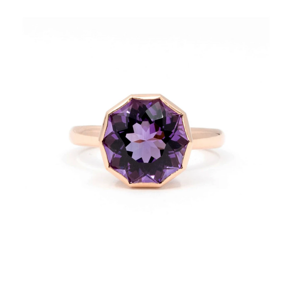 Fancy ring photographed on a white background. The jewel is in rose gold and features a big bezel set deep purple amethyst. This cocktail ring is available at Ruby Mardi, the best jewelry store in Canada.