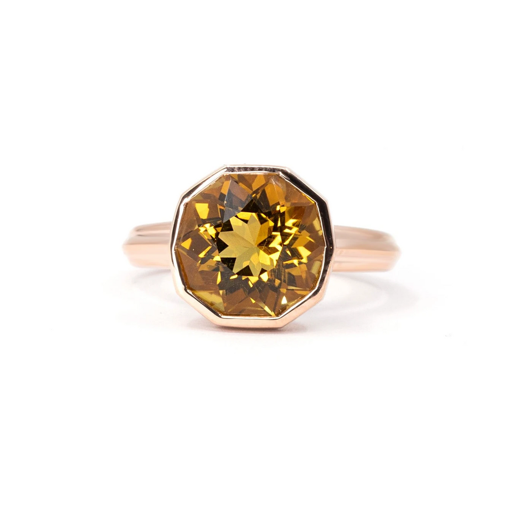 Large citrine bold bezel set ring seen from its face on a white background. It's a unisex rose gold statement ring designed by independent brand Bena Jewelry in Montreal, Canada.