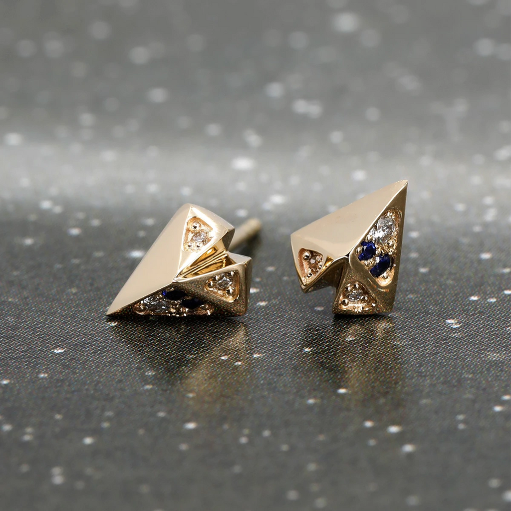 Splendid little yellow gold stud earrings with sapphires and diamonds. With their heart shape with volume and a rock look. The edgy and unisex style is the signature design of independent Canadian designer Bena Jewelry and represented by Montreal gallery and jewelry store Ruby Mardi.