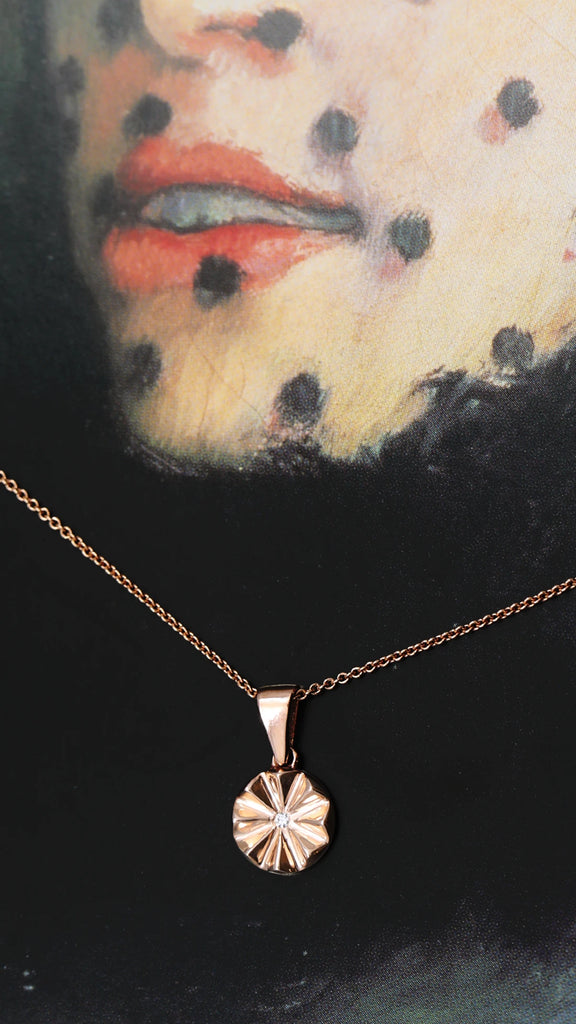 Artistic shot of our CHUM-my pendant, a rose gold pendant with a central lab grown diamond.  Handmade in Montreal by jewelry brand and store Ruby Mardi. 30% of sales are given back to the CHUM Foundation.