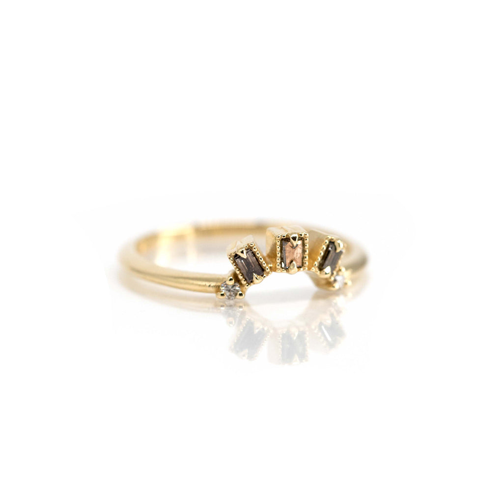 A dainty yellow gold wedding band with 3 champagne diamonds baguette cut photographed on a white background. Find it at high end jewellery store Ruby Mardi in Montreal.