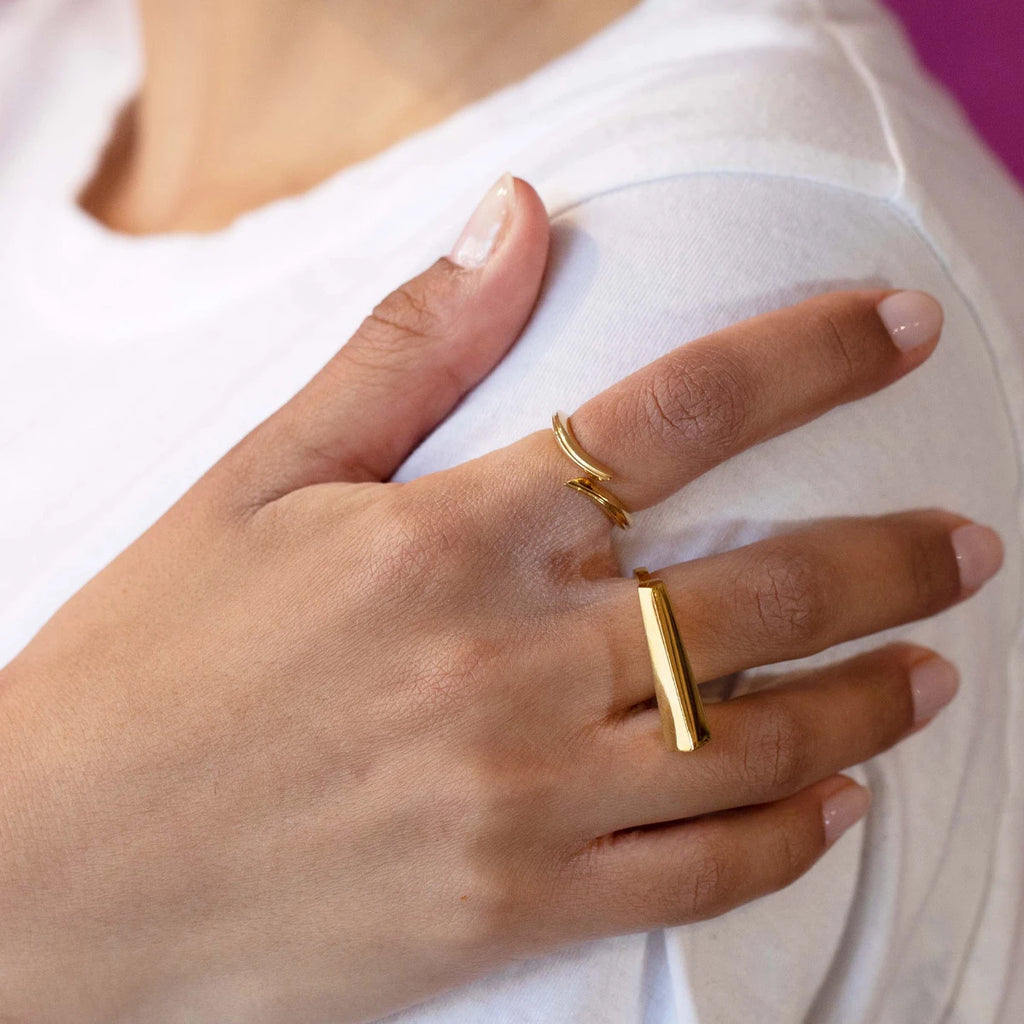 A lady is wearing two gold vermeil ring from Montreal designer Bena Jewelry. One ring is dainty and delicate, while the other is bold and sturdy. Modern jewels that you can rock in many fashions.