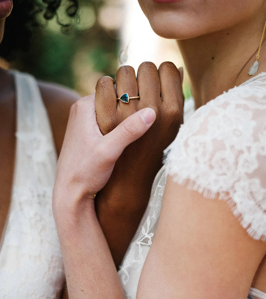 girls holding another girl's hand with a yellow gold bezel setting bridal ring made in little italy montreal for Ruby Mardi by Sheena jewellery outdoor photography