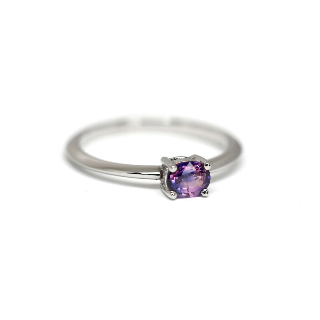 A magical two colours sapphire with pink and purple hues, set in 14k white gold and photographed on a white background. Beautiful, simple and elegant solitaire engagement ring. Find more jewelry at Ruby Mardi, the only fine jewelry gallery in Montreal.