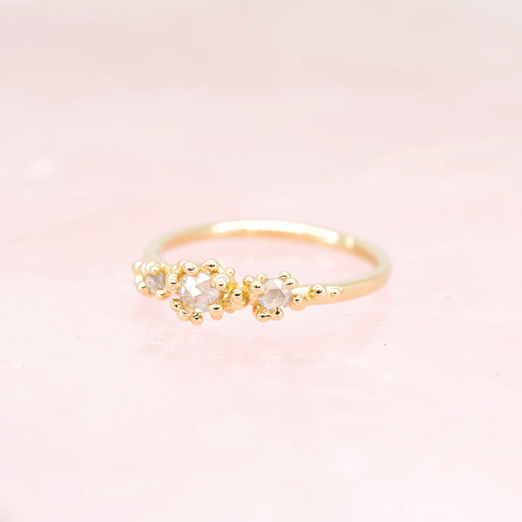 side view of dainty meg lizabet engagement ring for the best jewelry store in montreal boutique ruby mardi jeweler little italy bridal rings on a pink background