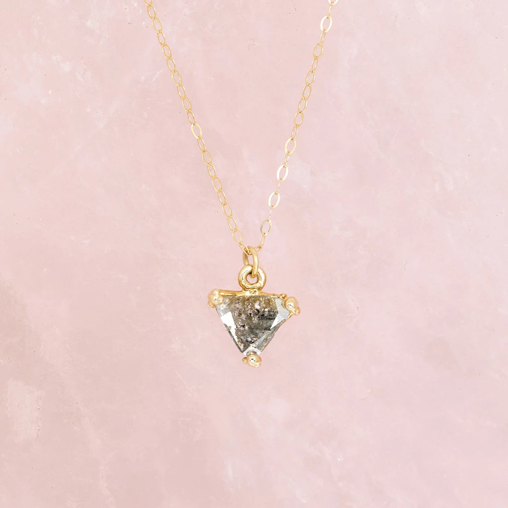 salt and pepper diamond montreal triangle shape with yellow gold pendant and dainty chaine made by the fine jewellery designer liane vaz for the best jewelry store in montreal boutique ruby mardi on pink background