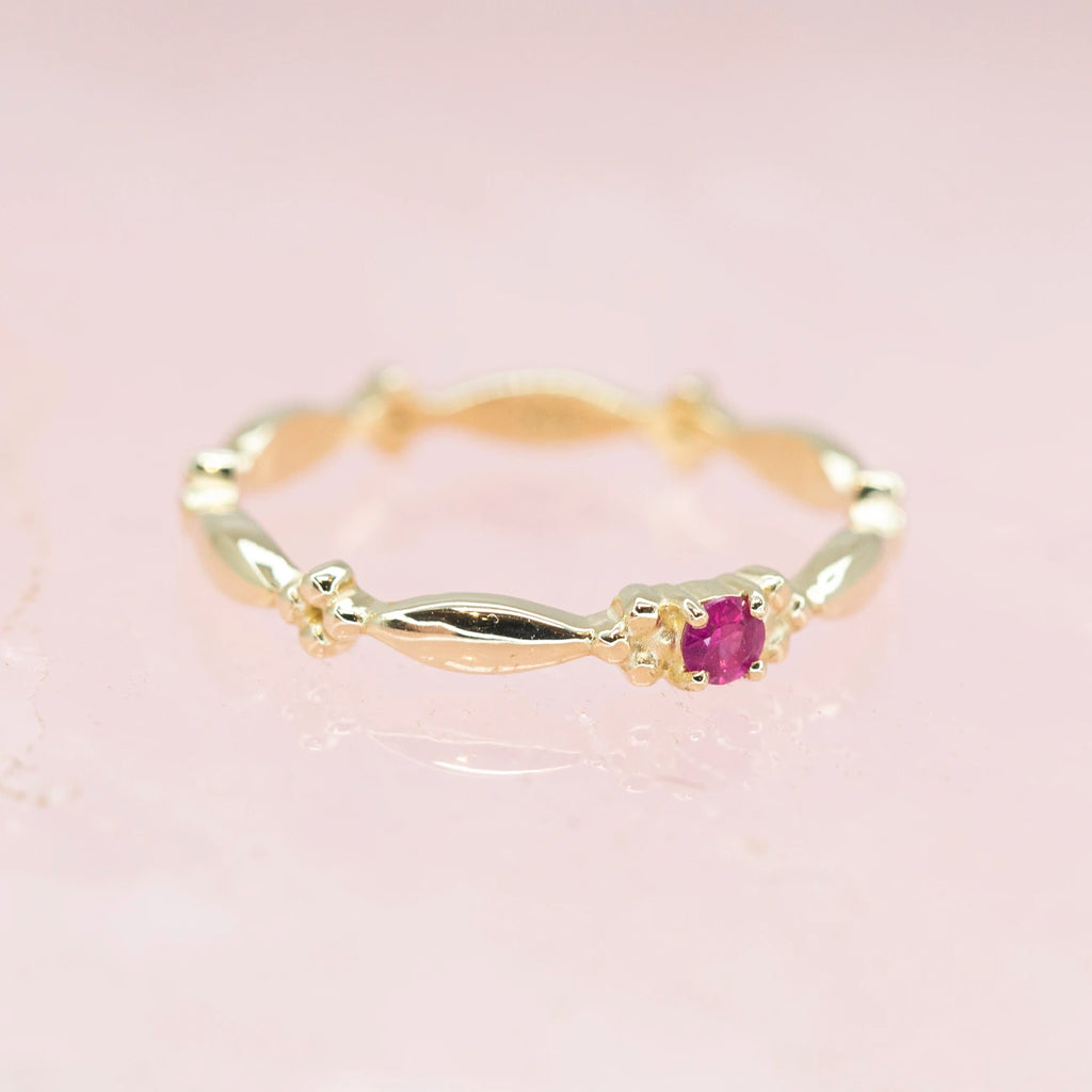 yellow gold small ruby bridal ring made in montreal by the jewelry designer Sheena Purcell for the boutique ruby mardi bespoke jeweller on a pink background
