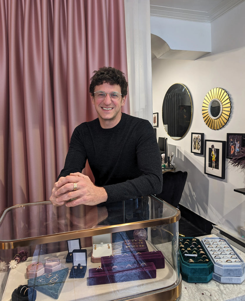 Victor Benaderette, jewelry designer and co-owner of jewellery store Ruby Mardi in Montreal, is posing in front of a jewelry display, inside his jewelry store.