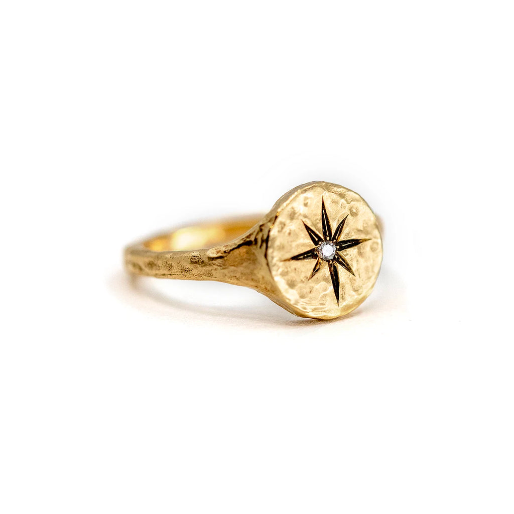 Side view on a white background of a handmade 14k gold hammered ring by Anouk Jewelry featuring a unique inner compass design and a natural 0.07 ct diamond. A one-of-a-kind (OOAK) artisan piece exclusively available at Ruby Mardi, the premier jewelry store in Canada.
