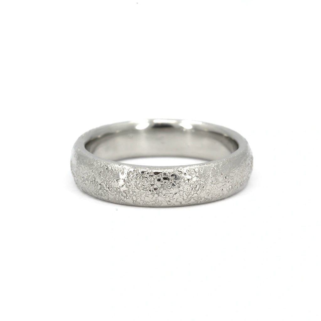 Handcrafted white gold wedding band with raw, cratered texture and soft domed shape, made by Fluid Jewellery and available at Ruby Mardi.
