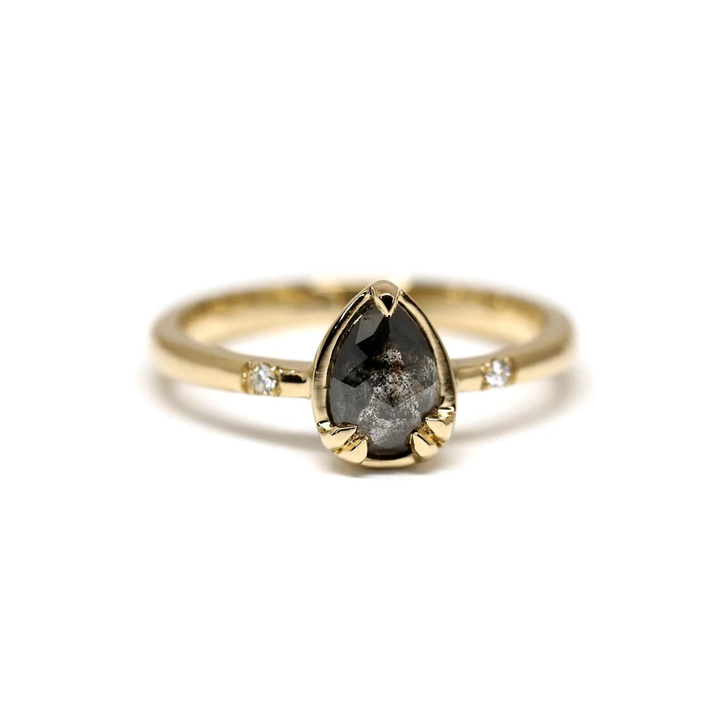 Black diamond - or salt and paper diamond - alternative engagement ring set in rose gold with white natural diamonds accents. This ring was handcrafted in Canada by Yuliya Chorna and is seen photographed on a white background.