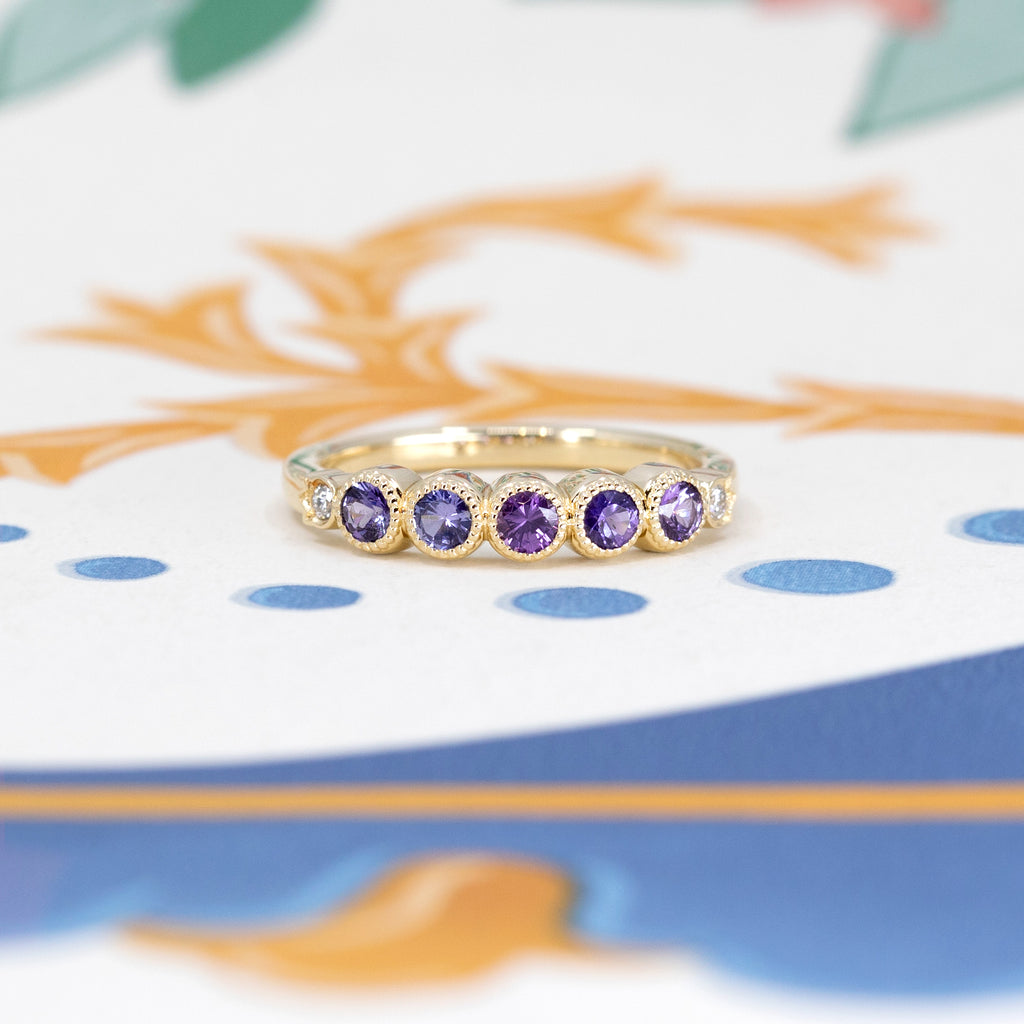 Discover the timeless elegance of this half eternity wedding band, featuring natural purple, pink and purplish sapphires, set in yellow gold. Created with passion by talented independent designer Bramston Goldsmithing in Canada, every detail of this bangle evokes art and love. Available for purchase exclusively at Ruby Mardi of Montreal, the reference in unique and handmade bridal jewelry.