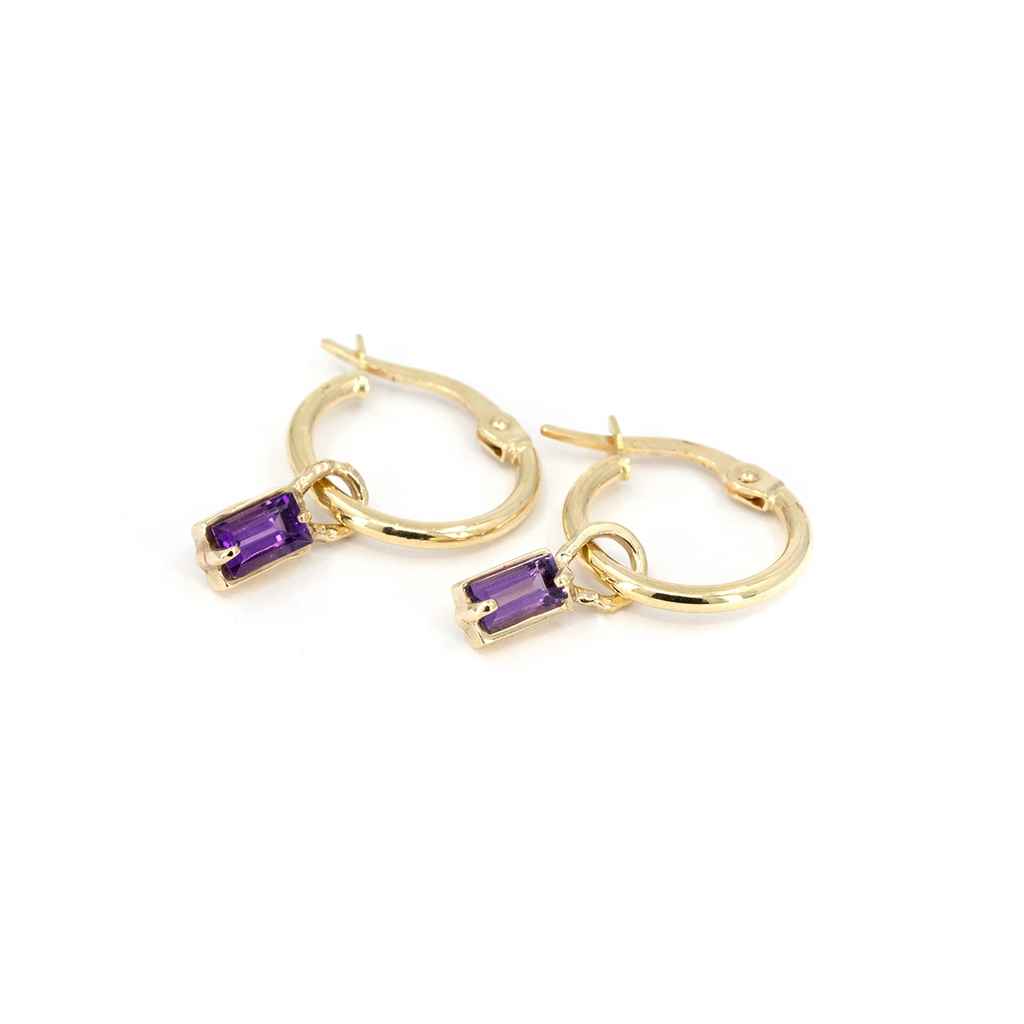 Close-up of 10k gold hoop earrings with small emerald-cut amethyst drops by Nadia Werchola, photographed at Ruby Mardi.