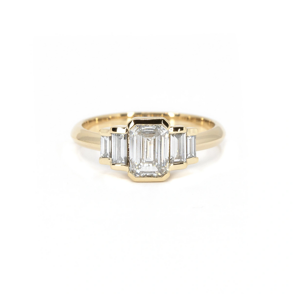 Bold and structured engagement ring with emerald-cut center diamond and tapered baguette side diamonds, set in 14k yellow gold. A modern take on vintage glamour from Ruby Mardi, handmade in Montreal and named Gatsby Glow.