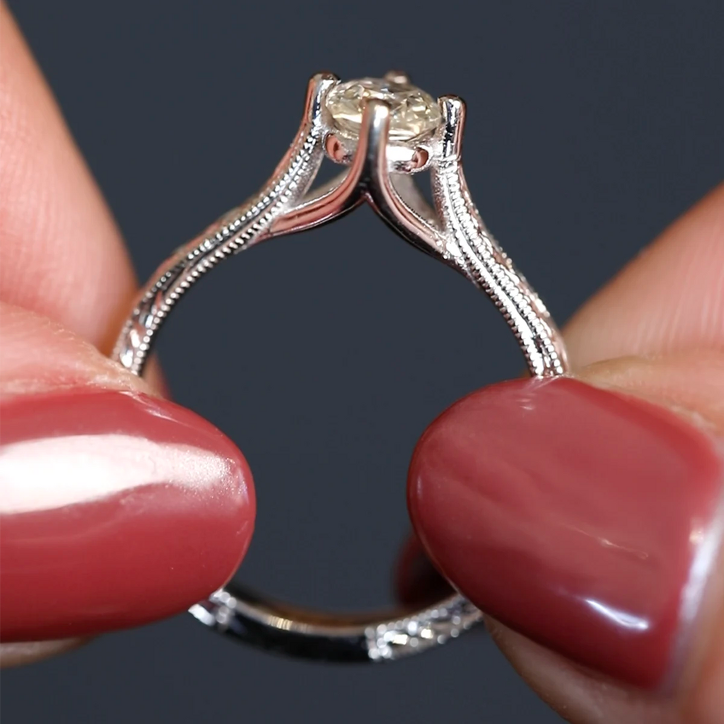 Close-up view of the sculptural prong setting on a 14k white gold engagement ring, featuring a pale yellow sapphire and detailed hand-engraved Art Deco band. Designed by Deborah Lavery, available at Ruby Mardi, Montreal.
