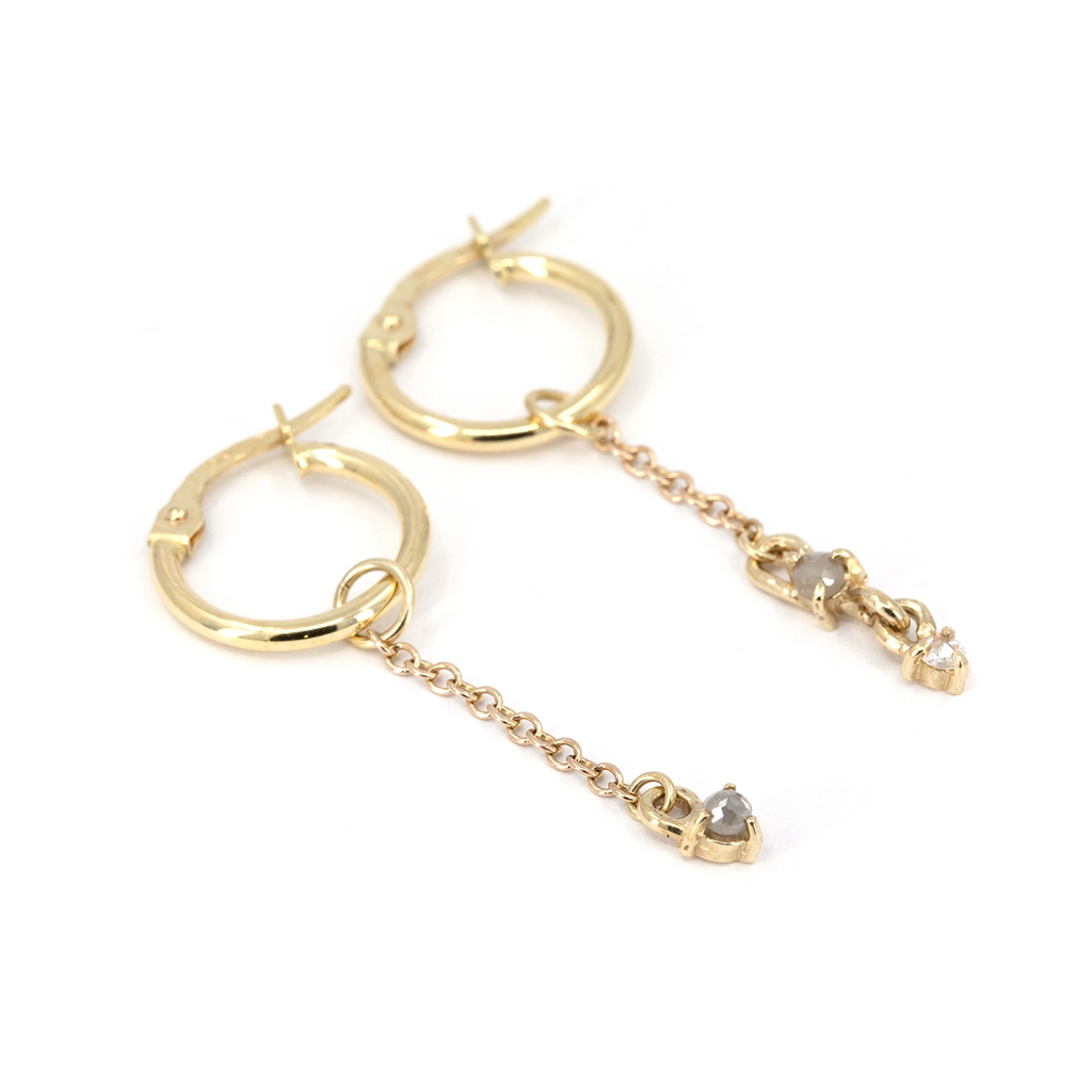 Asymmetrical 10k yellow gold hoop earrings with dangling chains set with two natural rose-cut grey diamonds and one rose-cut white diamond, handcrafted by Nadia Werchola, displayed on a white background for Ruby Mardi in Montreal.