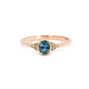 Rose gold engagement ring featuring an oval teal sapphire and champagne diamond accents, handcrafted in Montreal by Atelier Emigé for Ruby Mardi.