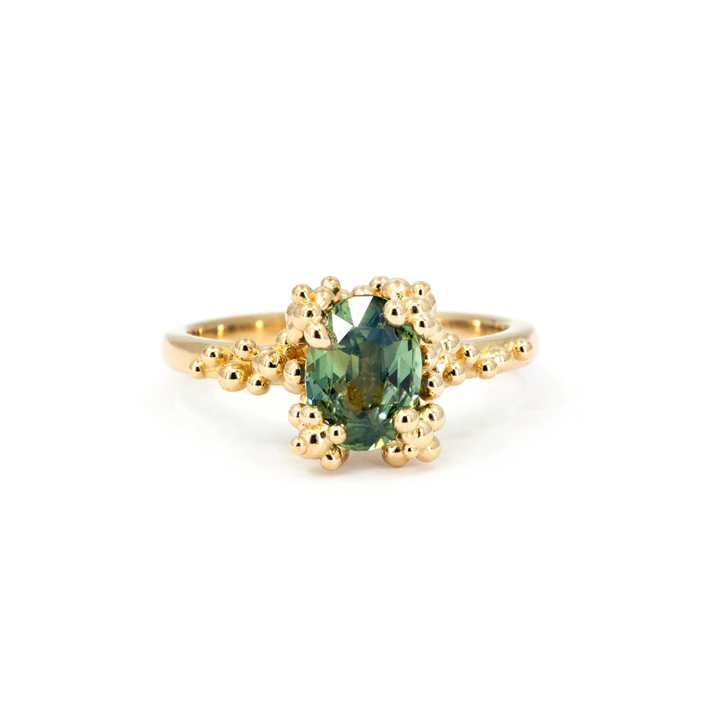 14k gold ring with 1.55ct oval green sapphire and textured gold bead setting, designed by Meg Lizabet. Alternative engagement ring from the Baleal collection, available at Ruby Mardi in Montreal.