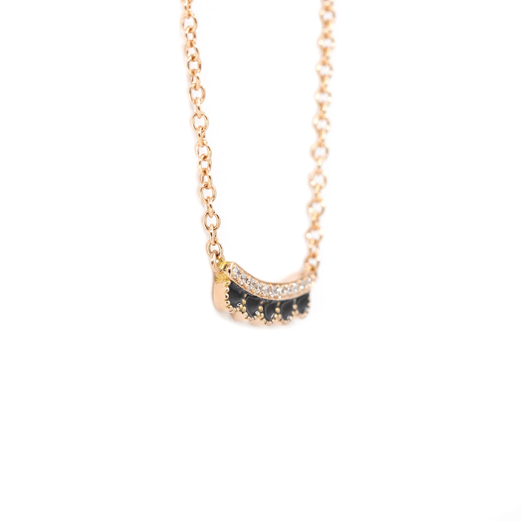 Side view of Ruby Mardi 14k rose gold scallop necklace by designer Emily Gill. Curved pendant with black enamel detail and natural diamonds for refined elegance.