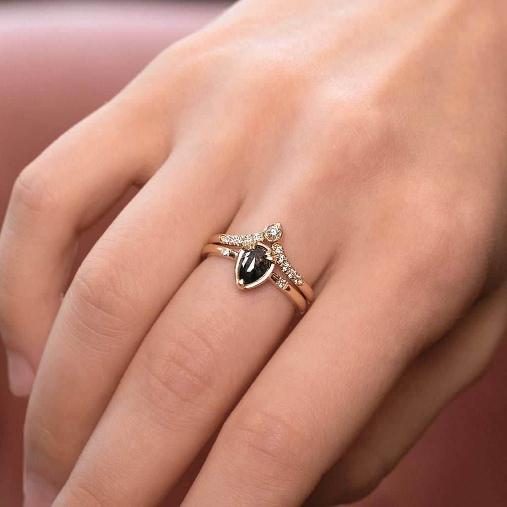 14k yellow gold diamond wave wedding band by Toronto designer Yuliya Chorna, paired with a marquise black diamond engagement ring. Elegant crown-style band with pavé-set diamonds and a pear-shaped gold detail holding a round diamond, designed to nest perfectly with unique engagement rings. Modern and original fine jewelry available at Ruby Mardi.