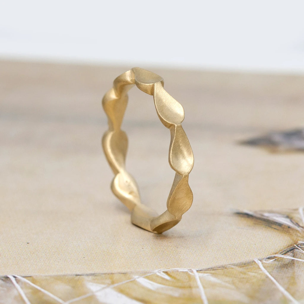 Gold wedding band made by independent designer Fluid Jewelry. This yellow gold bridal ring has a style with a small wave.