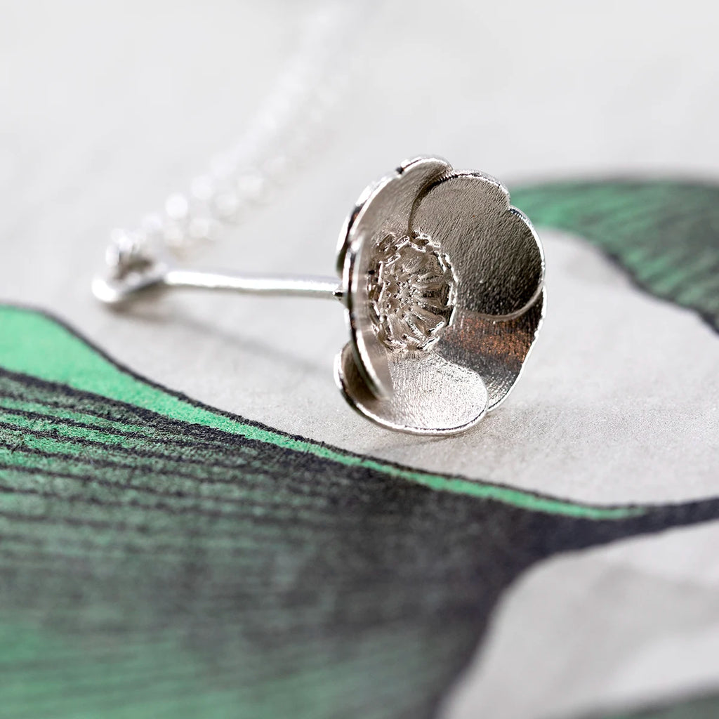 Side view of the white gold buttercup pendant by Fleurs Sauvages Qc, highlighting the handcrafted petals and natural shape. Unique floral jewelry from Ruby Mardi Montreal.