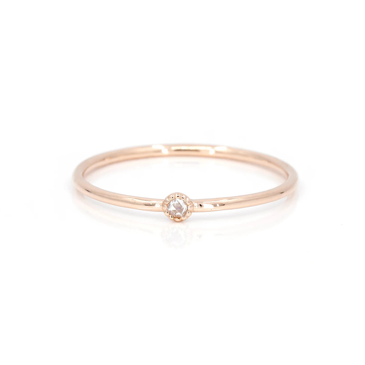 This delicate engagement ring is made in Montreal by independent jewelry designer Émigé. This jewel is made in pink gold with a splendid little champagne diamond in a bezel setting with a delicate miligrain. This splendid handmade artisanal creation is on sale at the best jewelry store in Montreal Ruby Mardi.