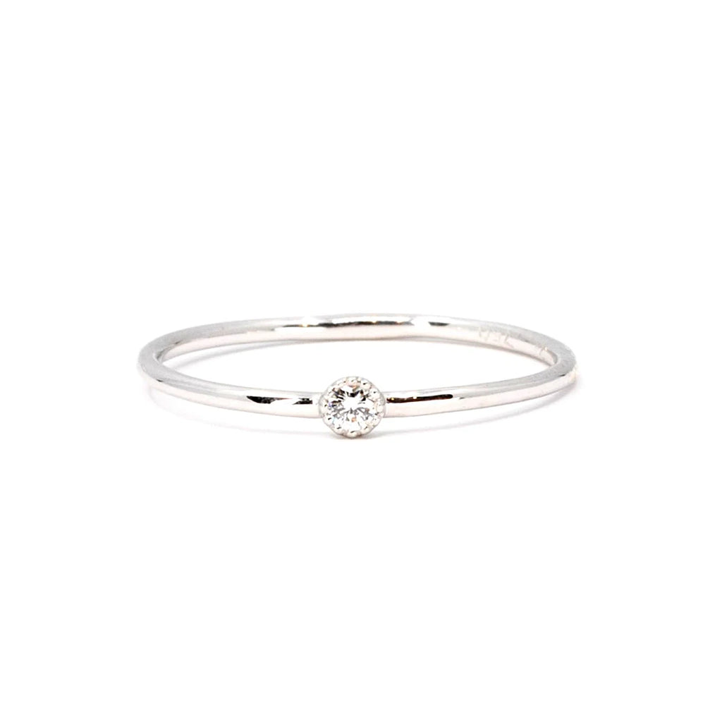 This dainty everyday ring is made in Montreal by independent jewelry designer Émigé. This jewel is made in white gold with a little Canadian  diamond in a bezel setting with a delicate miligrain. This splendid handmade artisanal creation is on sale at the best jewelry store in Montreal Ruby Mardi.