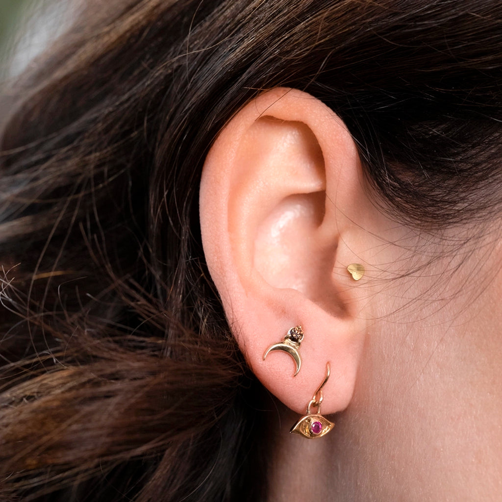 Chocolate diamond crescent-moon stud worn on ear, styled with other gold earrings, Nadia Werchola for Ruby Mardi.