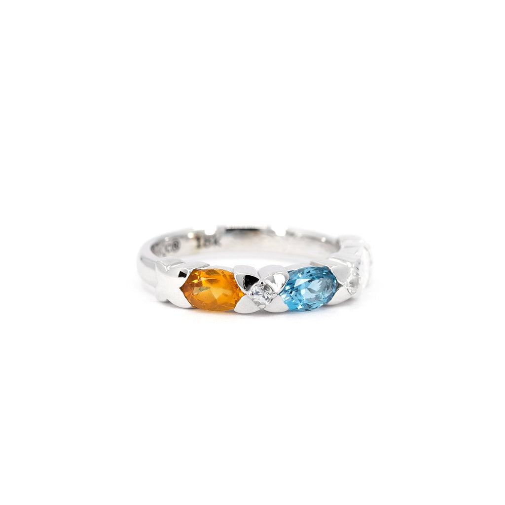 Artistic product photo of a colorful gemstone ring in 18k white gold, set with citrine, London blue topaz, and sparkling diamonds and sapphires, available at Ruby Mardi in Little Italy, Montreal.