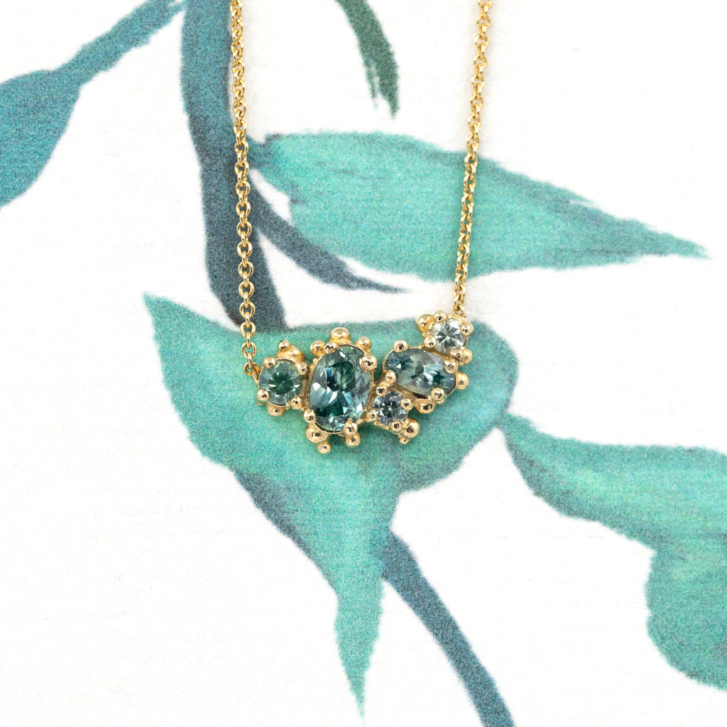Cluster sapphire necklace in 14k yellow gold with Montana teal sapphires by designer Meg Lizabet, fine jewelry from Ruby Mardi Montreal.