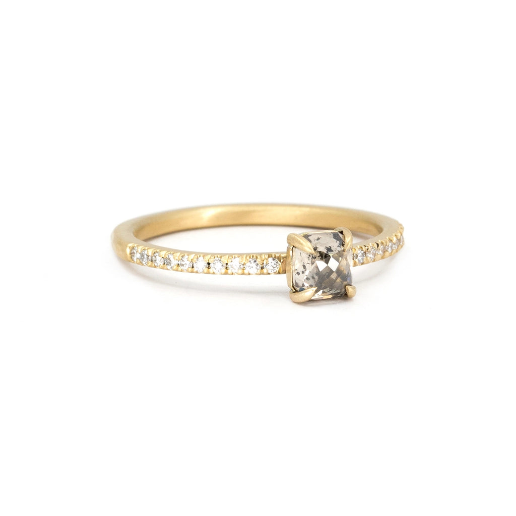 A classic solitaire engagement ring seen on a white background. The delicate piece of jewelry is set with small round brilliant diamonds. This bridal ring in 14k yellow gold (Ethical, Fairmined-Certified) was handcrafted in Canada by Fluid Jewellery. This video was filmed and edited by Ruby Mardi, the coolest jewelry store in Canada, that sells the jewels from indie Canadian jewelry designers, as Gem Breakfast does in the USA. 