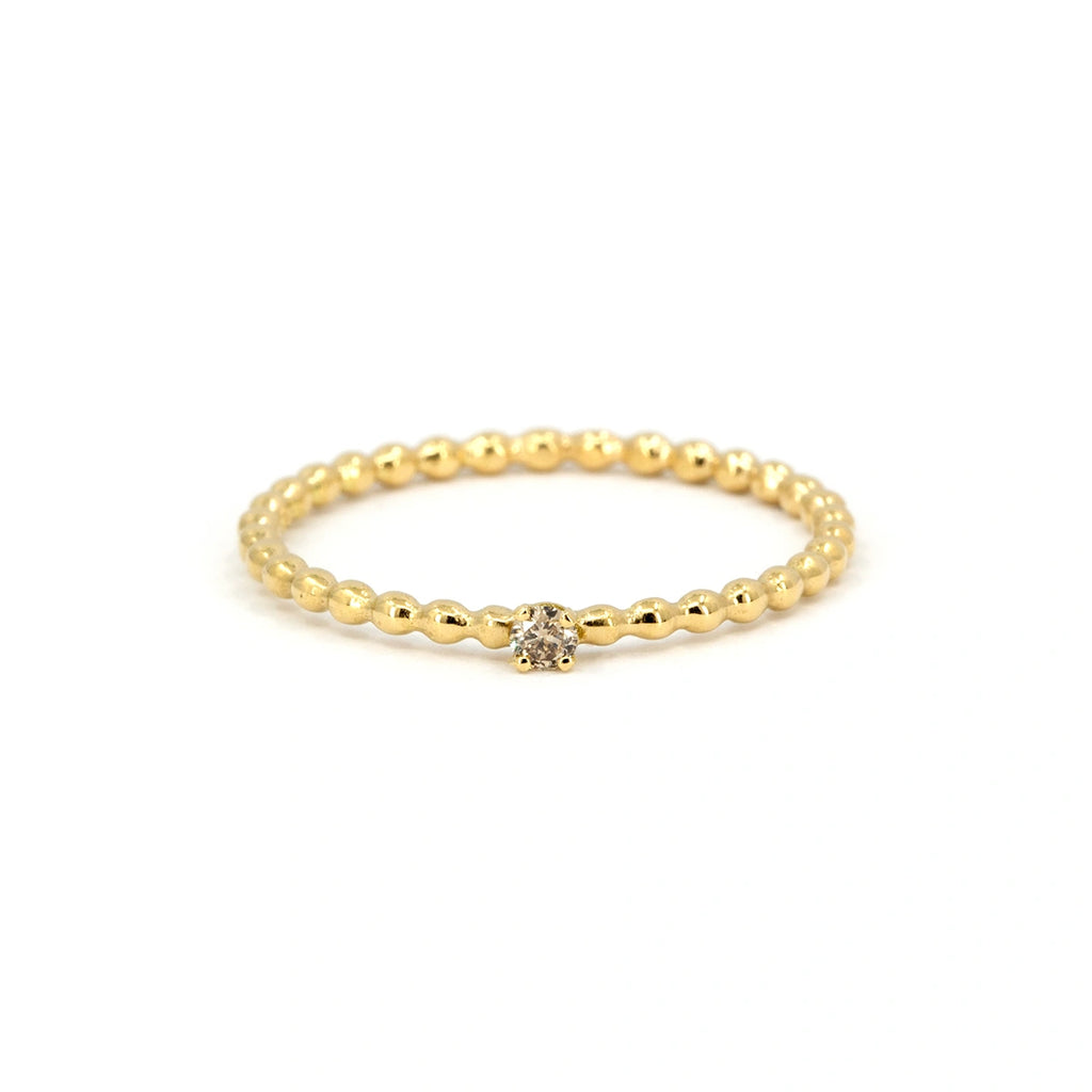 Dainty yellow gold ring with beaded band and small champagne diamond solitaire. Handmade by Atelier Emigé, available at Ruby Mardi, Montreal.