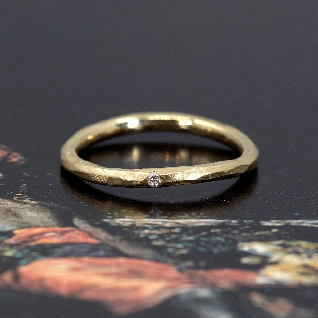 A twisted, hammered 2mm gold band with a small diamond accent, handcrafted by Sheena Purcell and available at Ruby Mardi—Montreal’s curated, one-of-a-kind jewelry destination.