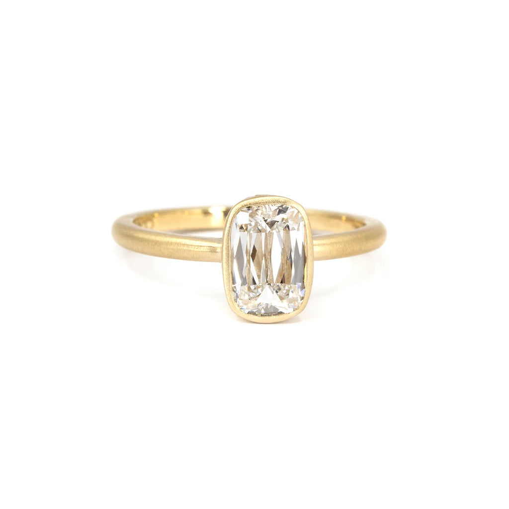 Diamond solitaire ring with custom antique cushion cut, set in a matte yellow gold bezel with subtle hand engravings. Made in Ottawa by Fluid Jewellery using Fairmined gold. Unique ethical engagement ring available at Ruby Mardi, Montreal.