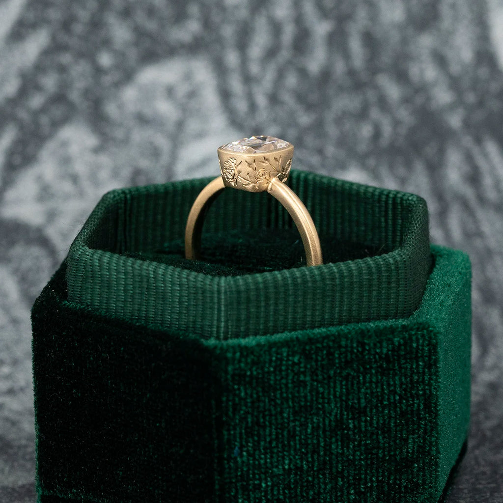 Hand-engraved solitaire ring with 1.25 ct antique-cut natural diamond, crafted in Fairmined gold. Made in Ottawa by Fluid Jewellery. Shown in green velvet ring box. Available at Ruby Mardi, the coolest jewelry store in Canada.