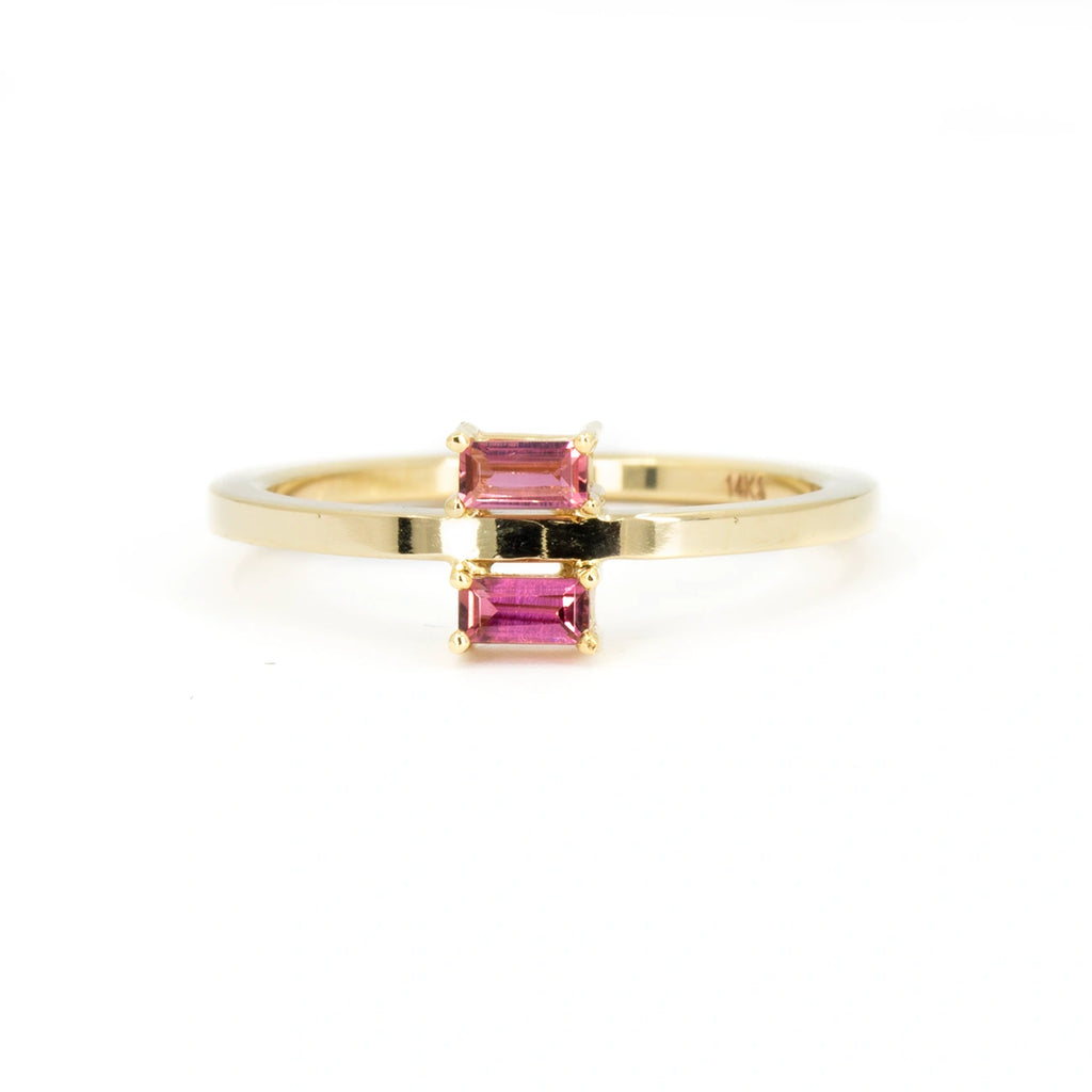 Front view on a white background of a designer gold ring featuring 2 tourmaline baguette, one on top and one above the flat gold band. It's a creation from independent brand In the Light of Day Jewelry. This one-of-a-kind ring is available at Canadian jewelry store Ruby Mardi, in Montreal.
