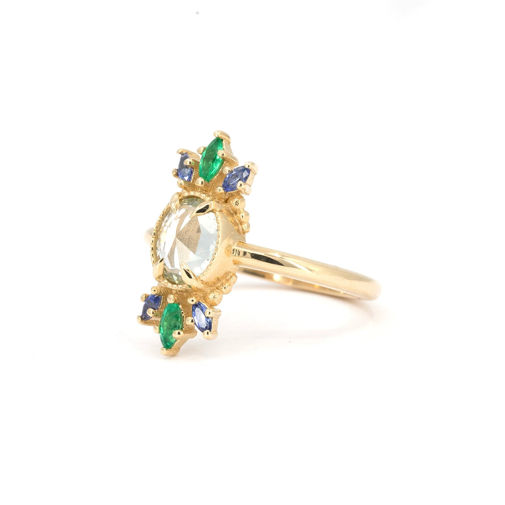Side view of the Nadia Werchola gold ring showing marquise blue sapphires and emeralds framing a central colorless sapphire. Handmade in Canada.