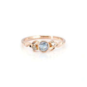 The independent jewelry designer Émigé presents the alternative engagement ring with a bezel-set light blue rose cut sapphire and two champagne diamonds. This custom creation is exclusive to the Ruby Mardi jewelry store in Montreal.