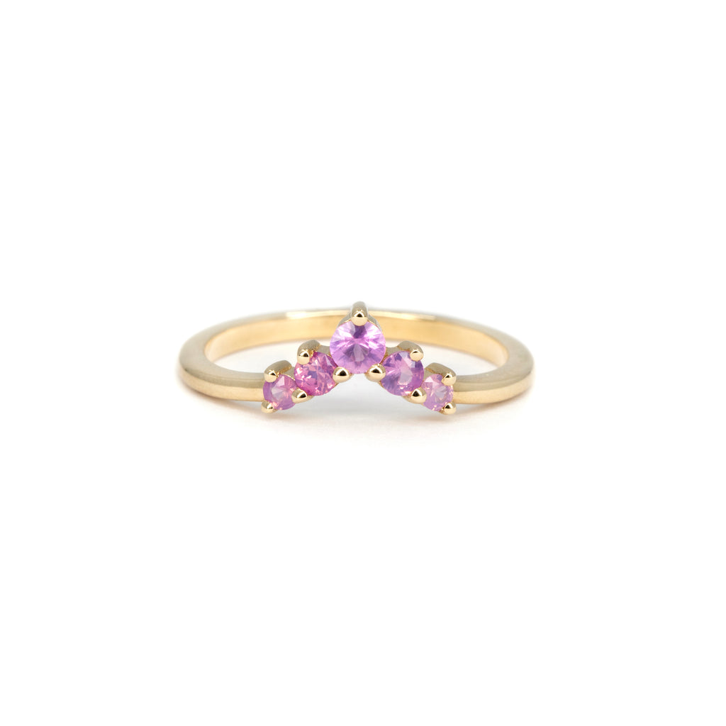 Fine gold contour ring with natural pink sapphires arranged in a soft crown shape. This dainty wedding band features a gradient of round pink sapphires set in 14k yellow gold, handcrafted in Toronto by independent jewelry designer Emily Gill. Perfect as a crown wedding band or colorful stacking ring, available exclusively at Ruby Mardi, the best fine jewelry boutique in Montreal, Canada.