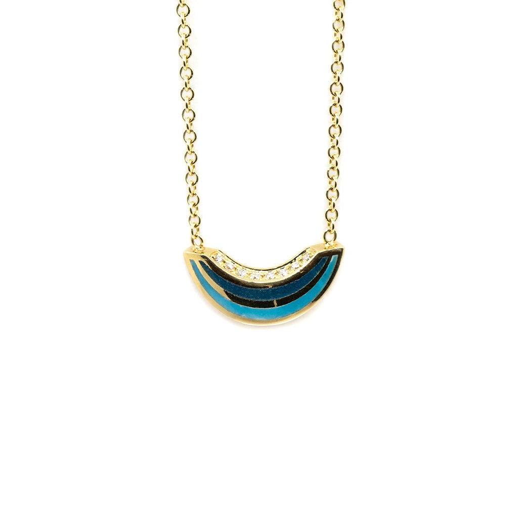 A 14k yellow gold necklace with blue and black enamel and diamond accents by Canadian designer Emily Gill, available at Ruby Mardi fine jewelry boutique in Montreal.