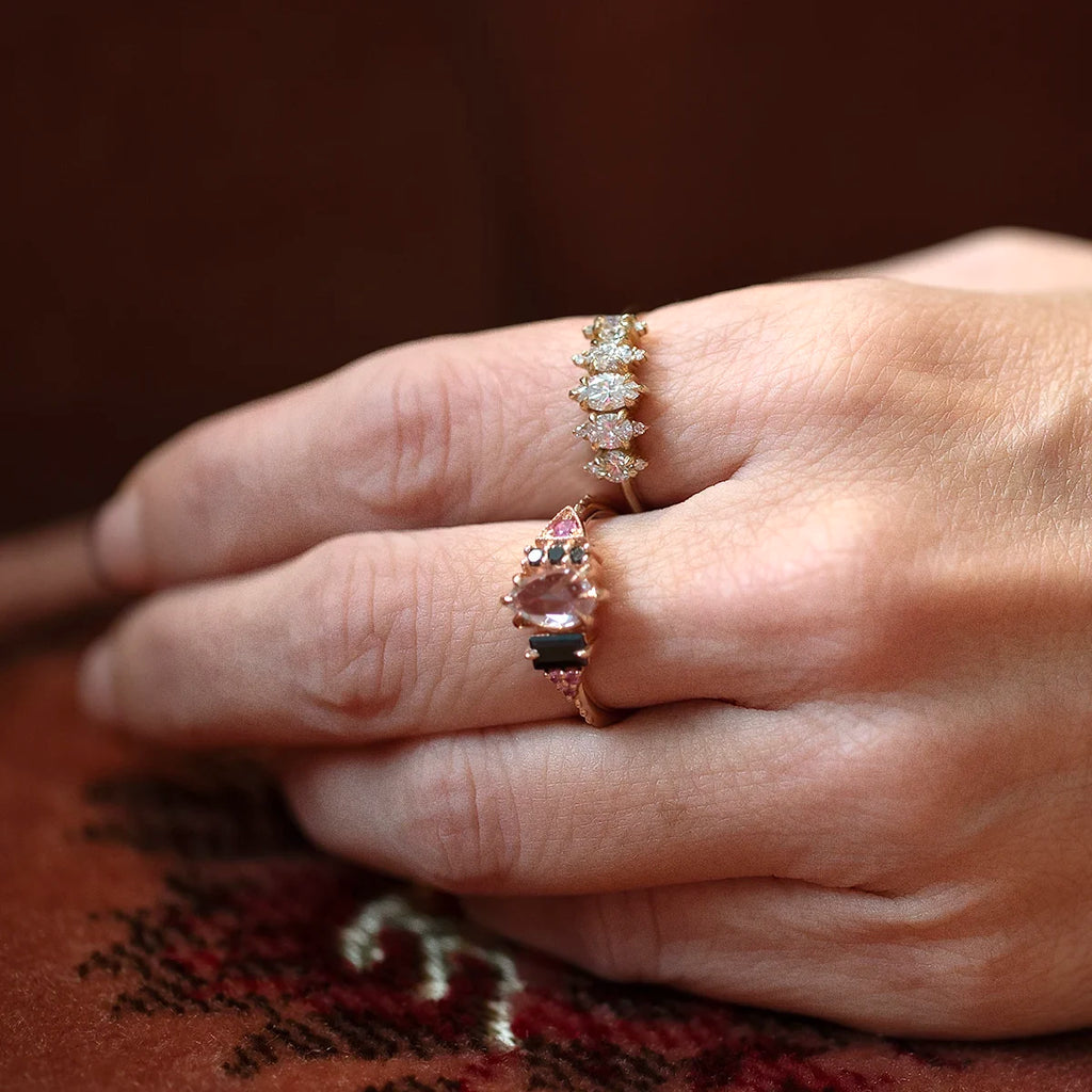 Hand wearing a diamond ring by Nadia Werchola, featuring round lab-created diamonds set in 10k yellow gold. The piece sits on the finger with a soft sparkle, photographed against a warm woven fabric for a natural, intimate feel.