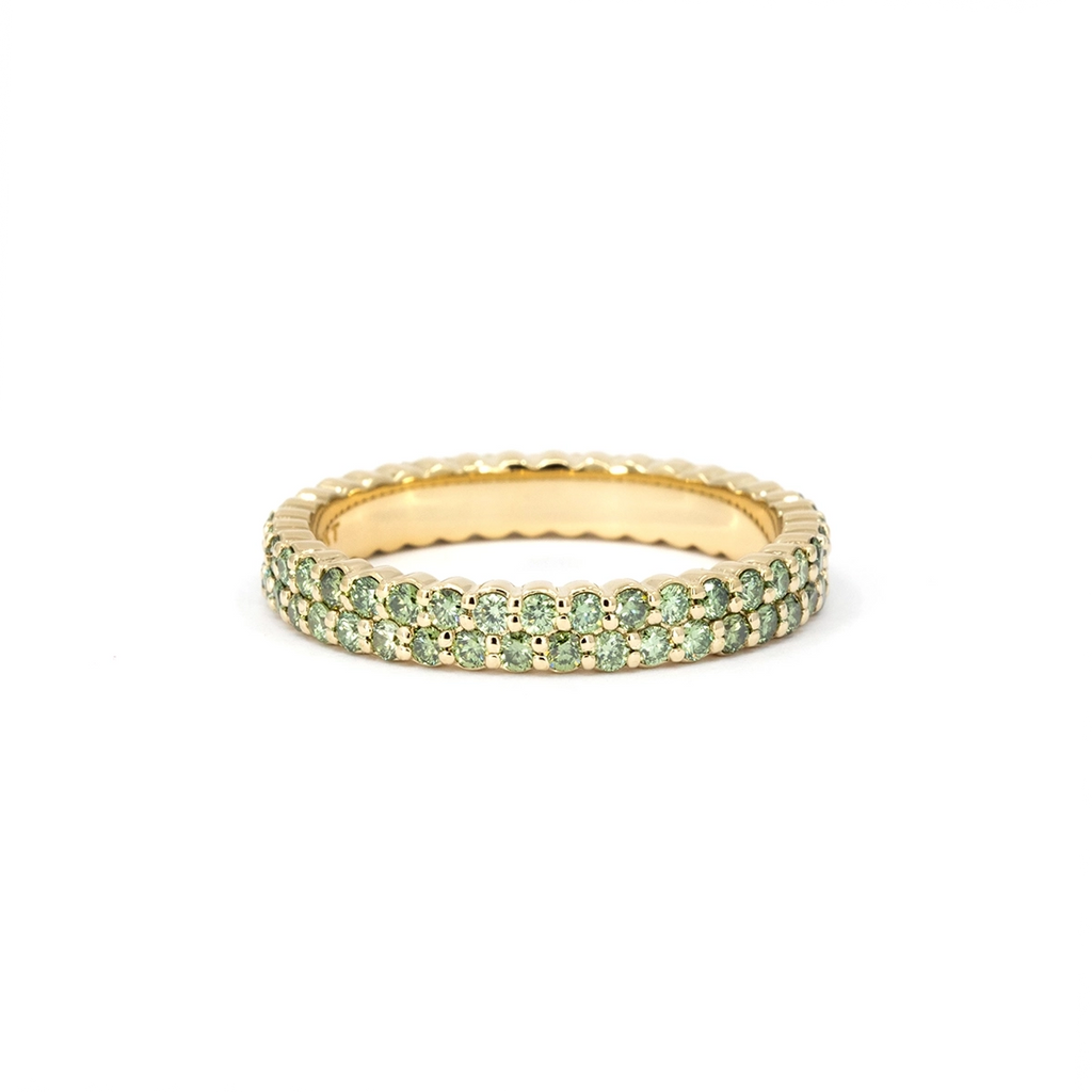 Double-row green diamond eternity band in 14k yellow gold from Ruby Mardi, Montreal. Close-up showing the vivid round green diamonds and polished gold profile, handcrafted by independent jewelers.