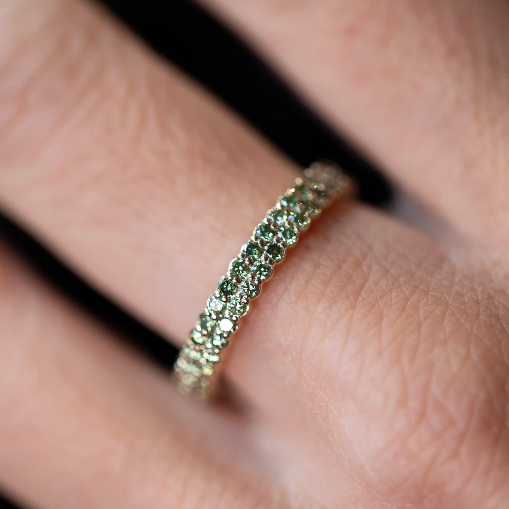 Green diamond double-row eternity band in 14k yellow gold, worn on hand. Fine contemporary design featuring two rows of light green diamonds with a scalloped profile. Handcrafted at Ruby Mardi, independent jewelry store in Montreal, Canada.