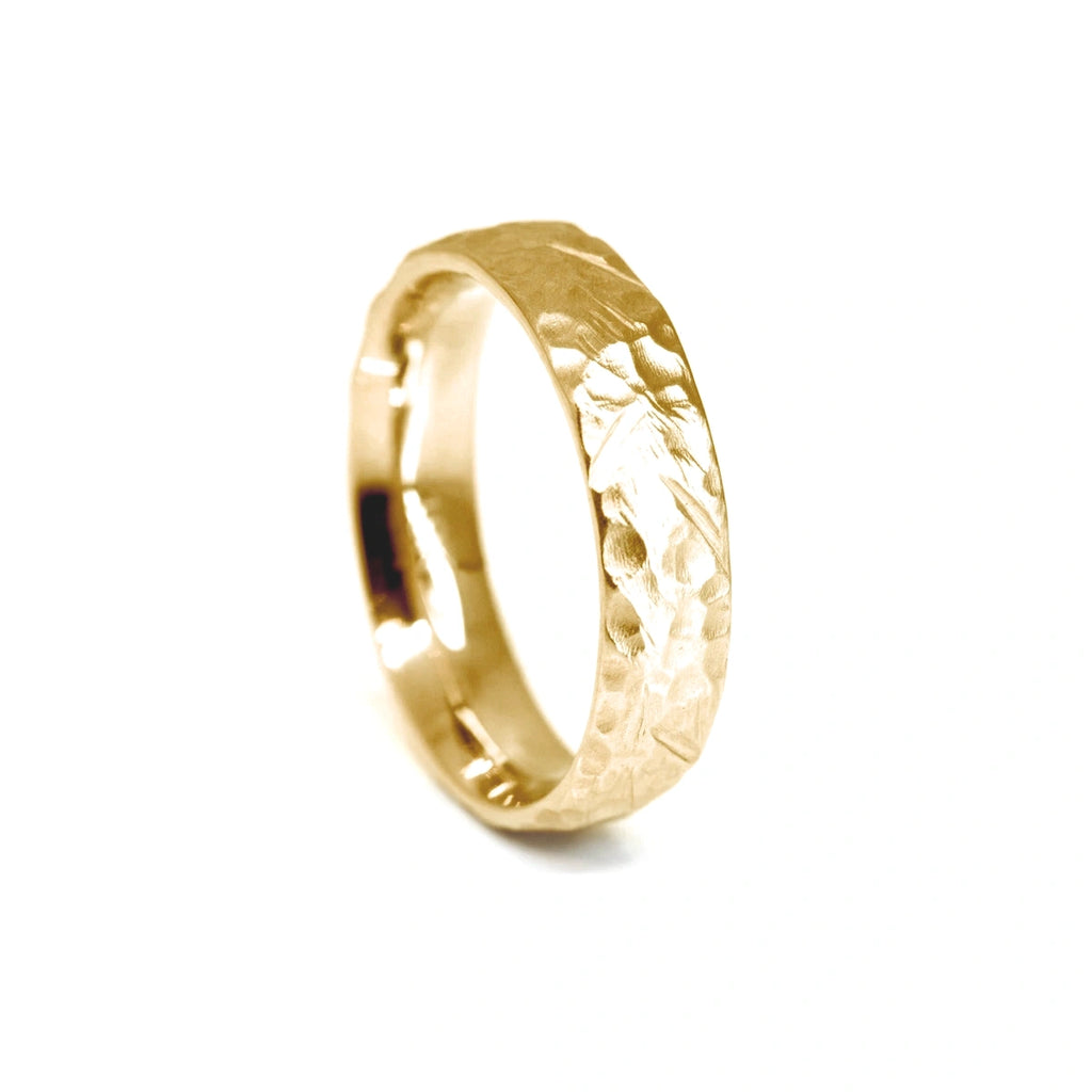 Textured wedding band 4mm for men, in yellow gold, seen on a white background.