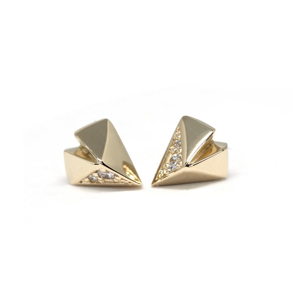 Diamond stud earrings with an edgy style photographed on a white background. The earrings have a funky heart shape and are casted in yellow gold. They have 4 small natural diamonds. This jewel was designed in Montreal by Bena Jewelry. 