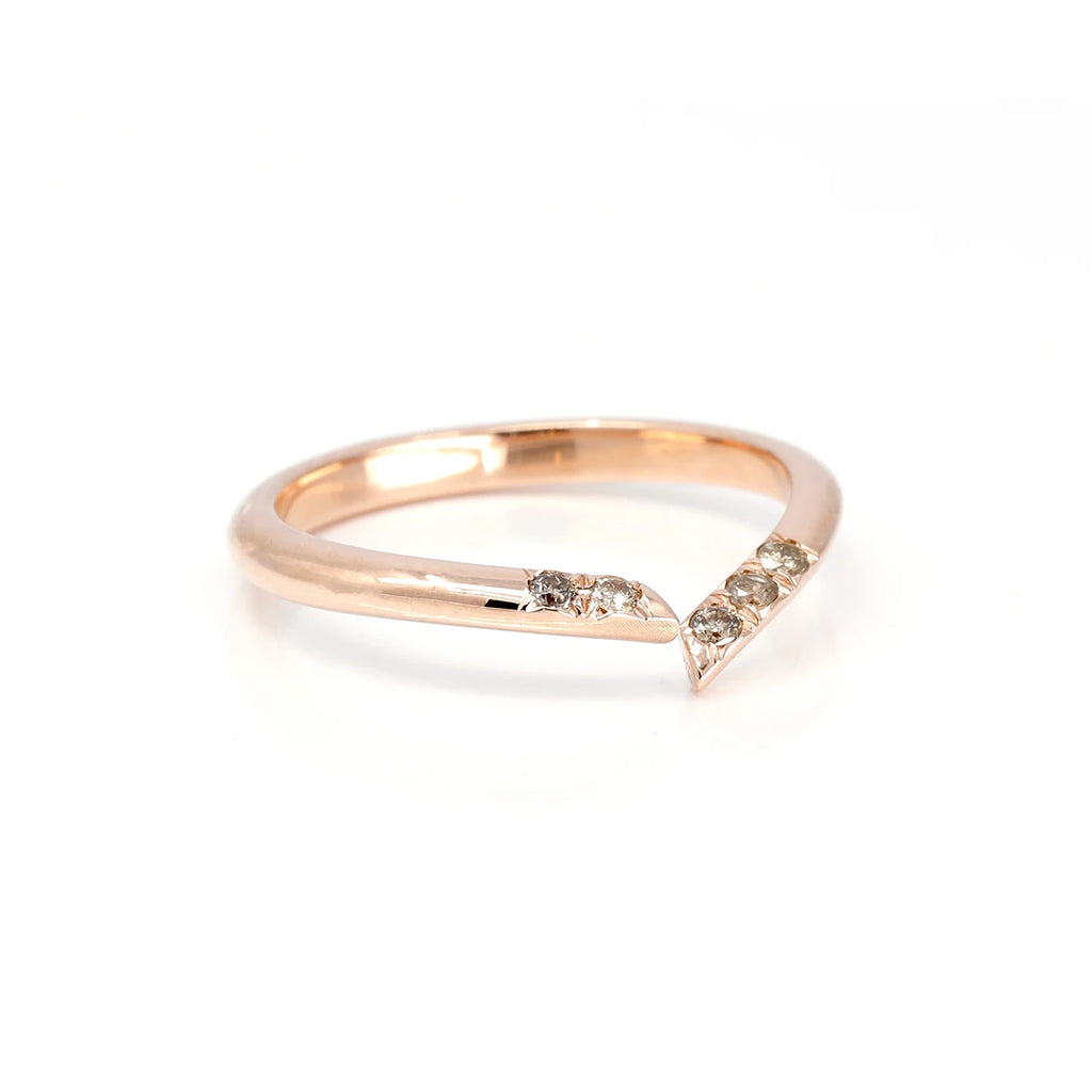 Side view on a white background of an open twisted rose gold wedding band with 5 small champagne diamonds set on the band.